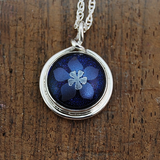pendant blue and silver columbine on blue dichroic glass in sterling silver bezel setting with round wire trim and top loop 